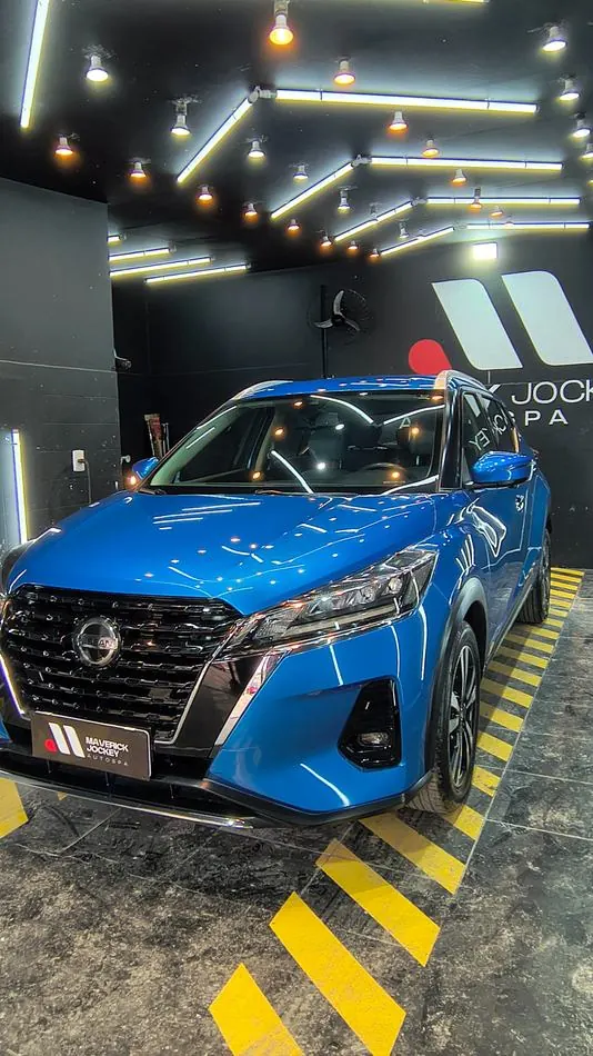 Nissan azul com acabamento brilhante no estúdio Maverick Jockey